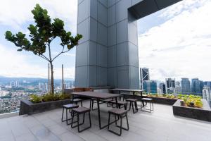 een tafel en stoelen bovenop een gebouw bij Royce KLCC Kuala Lumpur City Centre by Dormeo Destinations in Kuala Lumpur
