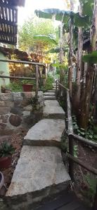 a stone path in a garden with a fence at Vila da Mata Hospedagem in Praia do Rosa