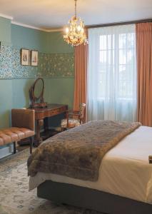 Portland Manor في Rheenendal: غرفة نوم بسرير ومكتب ونافذة