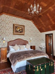 1 dormitorio con 1 cama grande y un baúl verde en Portland Manor, en Rheenendal