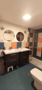 a bathroom with two sinks and a toilet and a mirror at Apartamento Eucalipto in Aguadulce