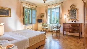 1 dormitorio con 1 cama, vestidor y ventanas en Villa Milani 14, Emma Villas, en Spoleto