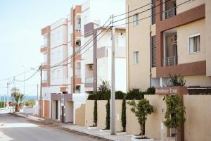 an empty street next to a tall building at Residence Trust in Sousse