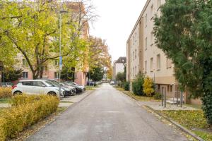 an empty street in a city with parked cars at Sunny apartment in Trnava in Trnava