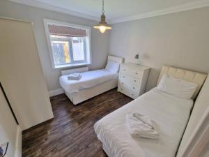 a small bedroom with two beds and a window at The Lakes Rookley in Rookley