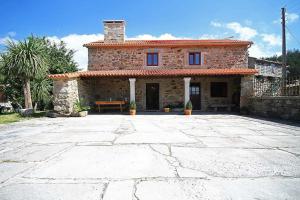 a stone house with a large driveway in front of it at Casa Agrelo Ria de Noia in Argellas
