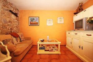 a living room with a couch and a tv at Casa Agrelo Ria de Noia in Argellas