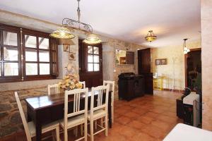 a kitchen and dining room with a table and chairs at Casa Agrelo Ria de Noia in Argellas