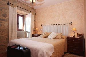 a bedroom with a bed with a suitcase at Casa Agrelo Ria de Noia in Argellas