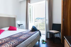 1 dormitorio con 1 cama y ventana con silla en Marina 10 Boutique&Design Hotel en Isquia