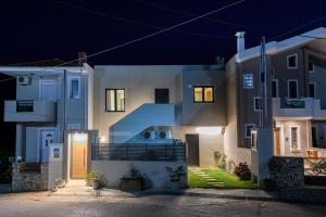 Una casa de noche con las luces encendidas en Archetypo Luxury Living en Chrysi Ammoudia