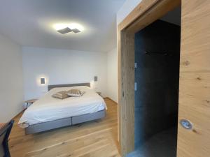 a bedroom with a bed and a door to a hallway at Berghof in Saas-Fee