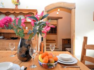 a table with a vase of flowers and a vase of fruit at 2 bed property in Tedburn St Mary MEDVI in Tedburn Saint Mary