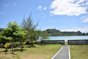 una pasarela junto a un cuerpo de agua en Pondok Oma for Solo Traveller en Lasikin