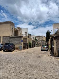 a street with cars parked in front of some buildings at Essy's Furnished Homes Nakuru with pool & GYM in Nakuru