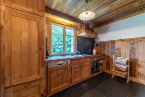 une cuisine avec des placards en bois et une fenêtre dans l'établissement DIFY Chalet au Coeur de Megeve, à Megève