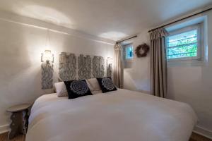 a bedroom with a white bed and a window at DIFY Chalet au Coeur de Megeve in Megève