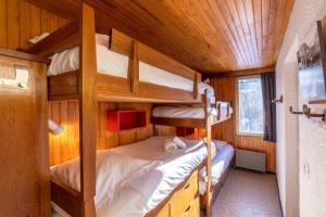 a bedroom with two bunk beds in a cabin at DIFY Grand Soleil - Courchevel 1650 in Courchevel