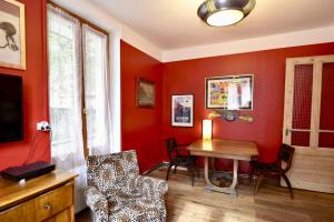 sala de estar con paredes rojas, mesa y sillas en DIFY Cosy - Chamonix, en Chamonix-Mont-Blanc