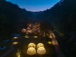 un groupe de sphères dans une cour la nuit dans l'établissement fabula glamping, à Kimitsu