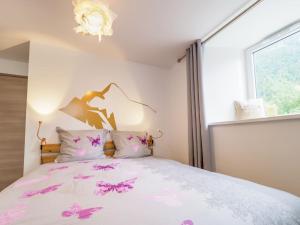 um quarto com uma cama com flores cor-de-rosa em DIFY Clos des Roches - Chamonix em Chamonix-Mont-Blanc