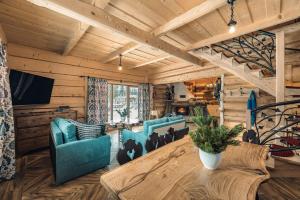 - un salon avec des murs en bois, une table et des chaises dans l'établissement Domek Między Dolinami, à Witów