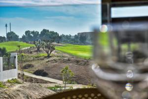 a view of a golf course from a wine glass at Santorini Taghazout - T2 luxe-piscine - 3 or 4 Px in Tamraght Ouzdar