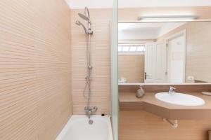 y baño con ducha y lavamanos. en Apartamento con vistas al mar golf piscina bbq, en San Miguel de Abona
