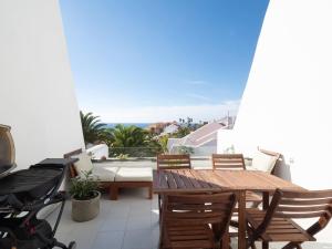 un patio con mesa, sillas y el océano en Apartamento con vistas al mar golf piscina bbq, en San Miguel de Abona