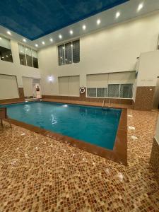 una gran piscina en un edificio con suelo de baldosa en كورال بيت العطلات en Al Khobar