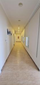 an empty hallway in a building with a tile floor at كورال بيت العطلات in Al Khobar