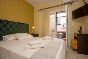 - une chambre avec un grand lit blanc et des serviettes dans l'établissement Nefeli by Heloni Apartments, à Athènes