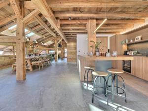 une grande cuisine avec des plafonds en bois et des tabourets de bar dans l'établissement Chalet Morzine, 7 pièces, 14 personnes - FR-1-627-72, à Morzine