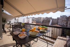 - un plateau de nourriture sur une table sur un balcon dans l'établissement Nefeli by Heloni Apartments, à Athènes