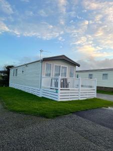 una casa blanca con una valla en el césped en Two bedroom Holiday home, en Newquay