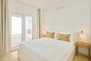 ein weißes Schlafzimmer mit einem großen weißen Bett und einem Fenster in der Unterkunft Encanto Costero Bungalow Acogedor en Golf del Sur, Tenerife in San Miguel de Abona + 43 Fotos