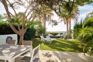 eine Terrasse mit Tisch und Stühlen und dem Meer in der Unterkunft Encanto Costero Bungalow Acogedor en Golf del Sur, Tenerife in San Miguel de Abona