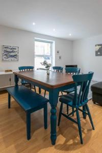 a dining room table with blue chairs and a table at Ethlebert Motel; in Margate