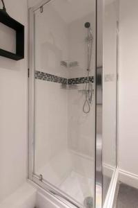 a shower with a glass door in a bathroom at Ethlebert Motel; in Margate