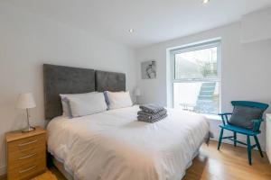 a bedroom with a bed with a blue chair and a window at Ethlebert Motel; in Margate