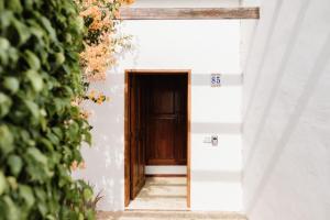 Una puerta en un edificio blanco con un cartel. en Bungalow frente al mar golf piscina, en San Miguel de Abona