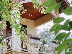 Un balcón de una casa con flores. en vita homestay Măng Đen en Kon Von Kla