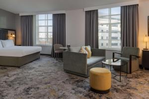 カーディフにあるヒルトン カーディフのベッド、ソファ、椅子が備わるホテルルームです。