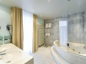 bagno con vasca, lavandino e doccia di Mercure Hotel Dortmund Centrum a Dortmund