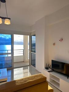 een woonkamer met een bank en een televisie bij Deep Blue Sea View Apartments in Sarandë
