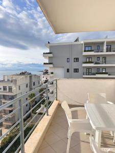 een balkon met een tafel en stoelen en uitzicht bij Deep Blue Sea View Apartments in Sarandë