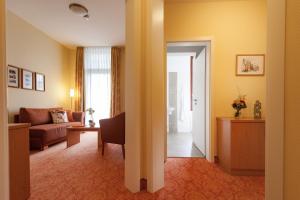 バート・ハルツブルクにあるVitalhotel am Stadtpark Superiorのリビングルーム(ソファ、椅子、ドア付)