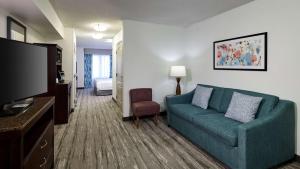 a living room with a couch and a tv at Hilton Garden Inn Merrillville in Merrillville