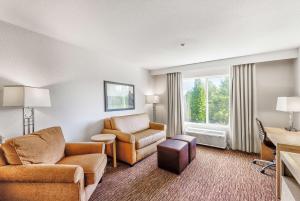 una sala de estar con sofá y sillas en una habitación de hotel en DoubleTree by Hilton Vancouver, en Vancouver