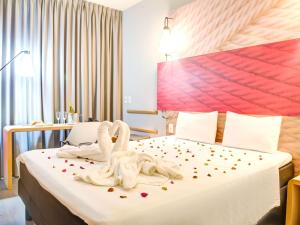 um quarto de hotel com dois cisnes sentados numa cama em ibis Paranagua em Paranaguá